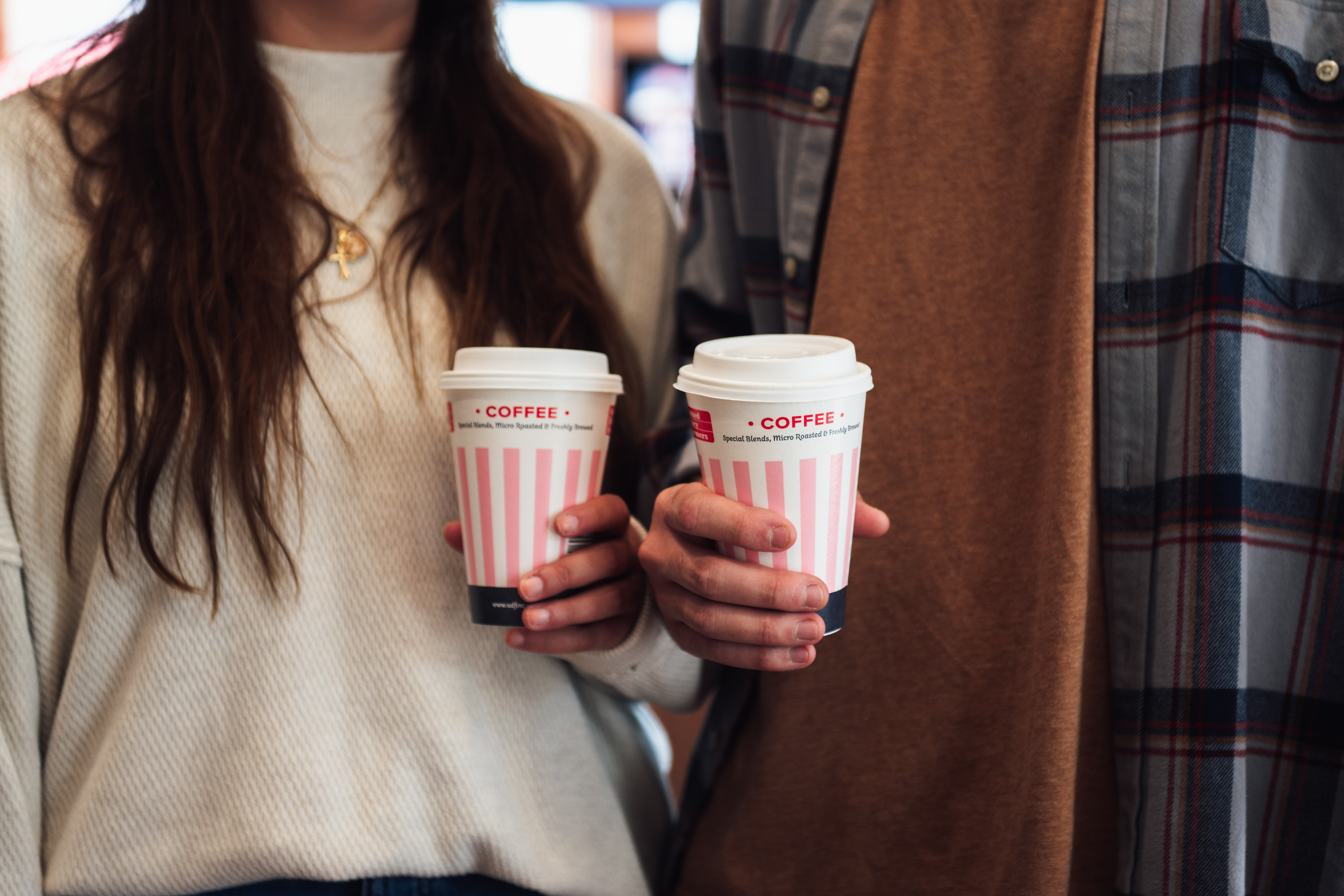 Happy couple holding UDF coffee