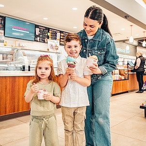 Boy and girl with mother enjoying ice cream