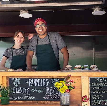 Cheerful Small Business Owners Posing Inside Food Truck Window