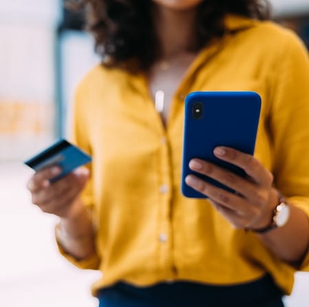 Woman Holding Payment Card And Smartphone For Digital Banking