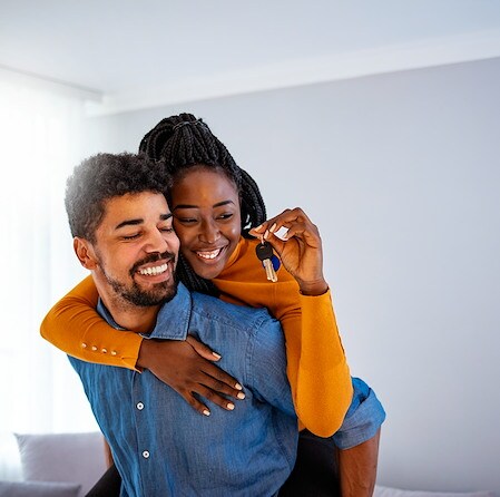 Happy couple holding keys to a new house