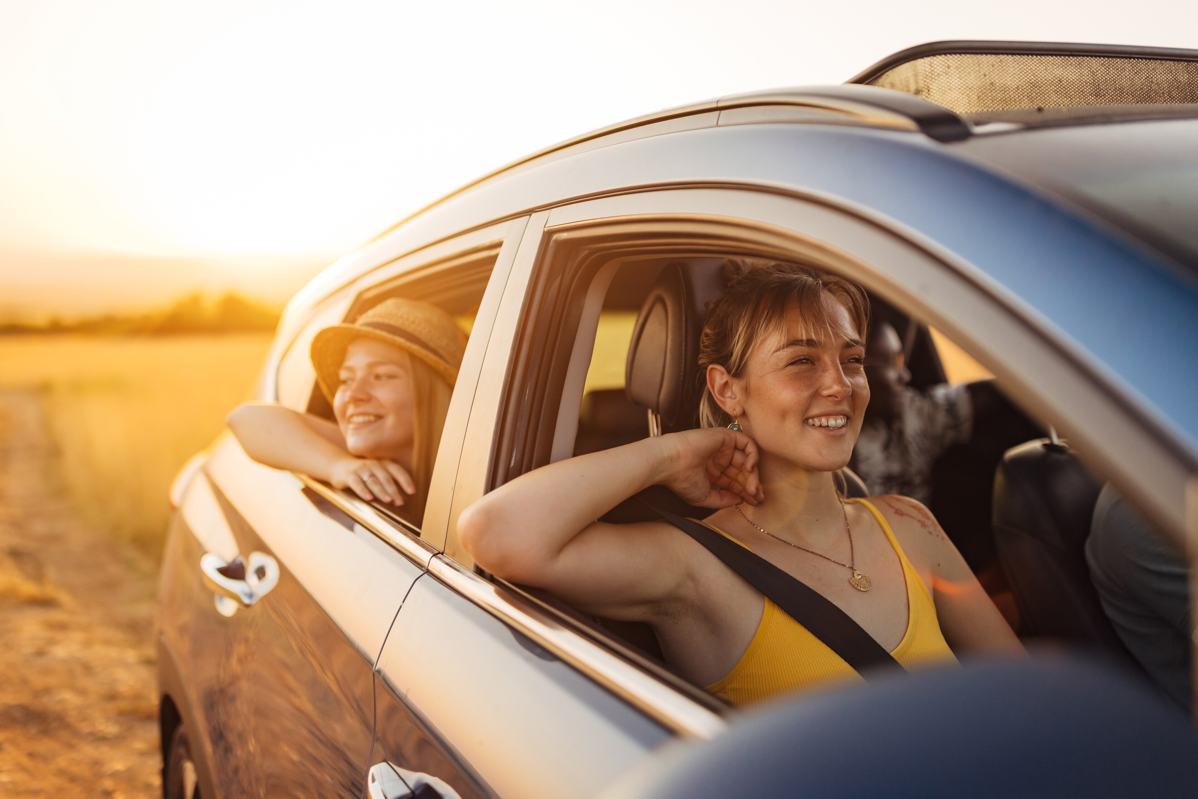 Two Young Women Enjoying A Sunny Road Trip In Car