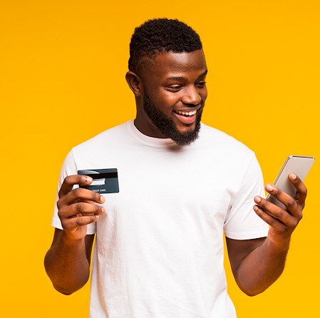 Smiling Man Holding Credit Card And Smartphone For Digital Banking