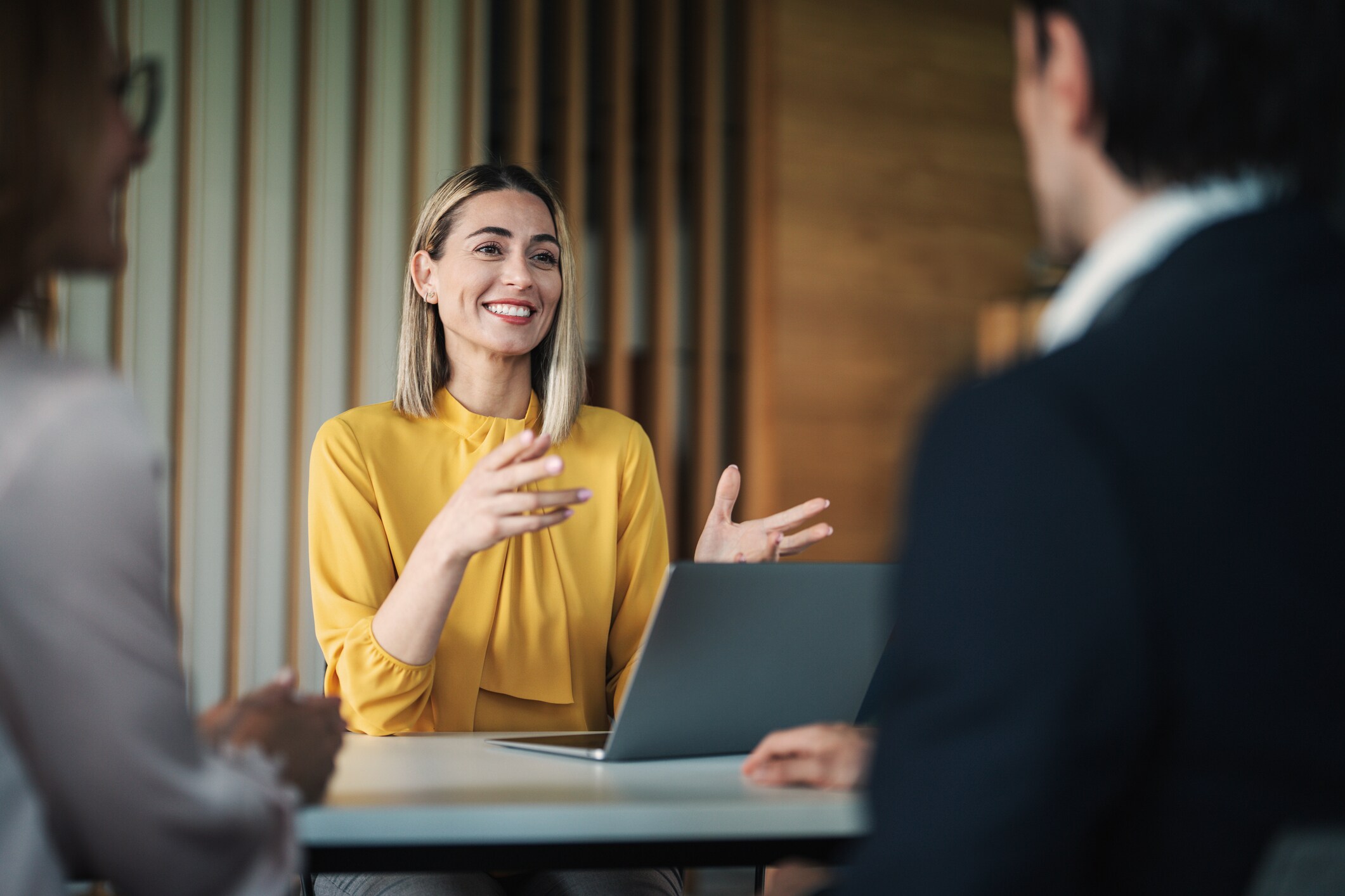 Smiling Professional Speaking In Meeting With Laptop On Table