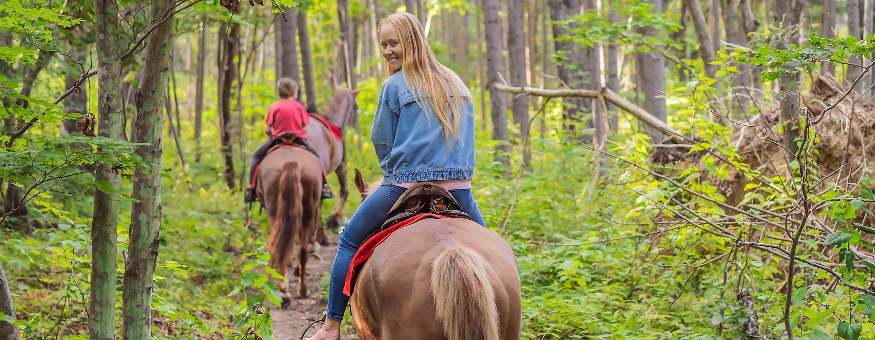 Adventures on the Gorge Lansing West Virginia USA - People ride horses along a narrow forest trail