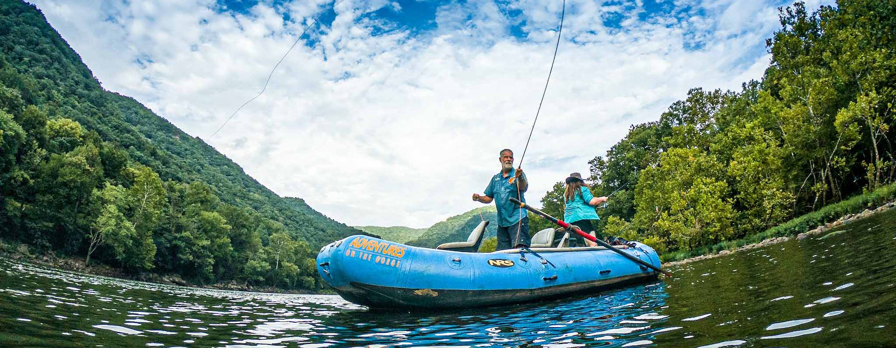 Couple are fishing from a blue inflatable raft on a calm river Adventures on the Gorge - Lansing West Virginia USA