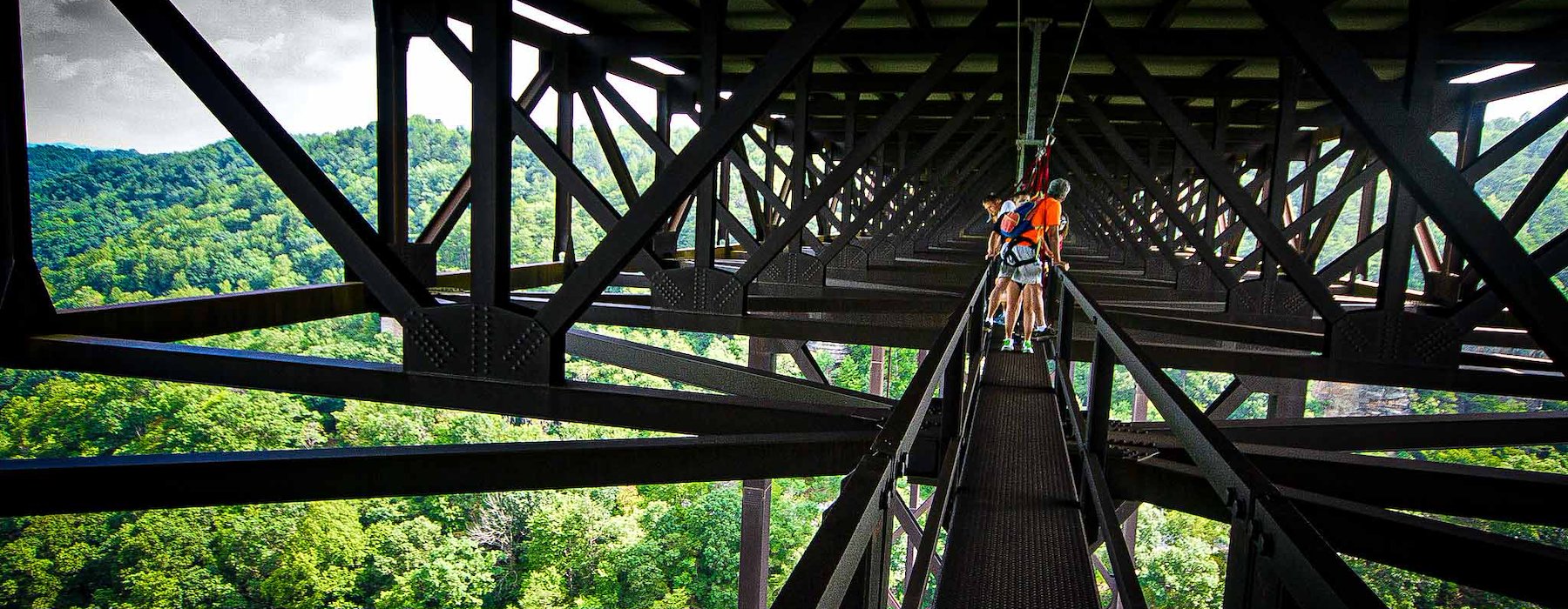 Glides On A Zip Line Above A Lush Forest, Enjoying The Thrill Of The Bridge Walk Adventure on the Gorge - Lansing West Virginia USA