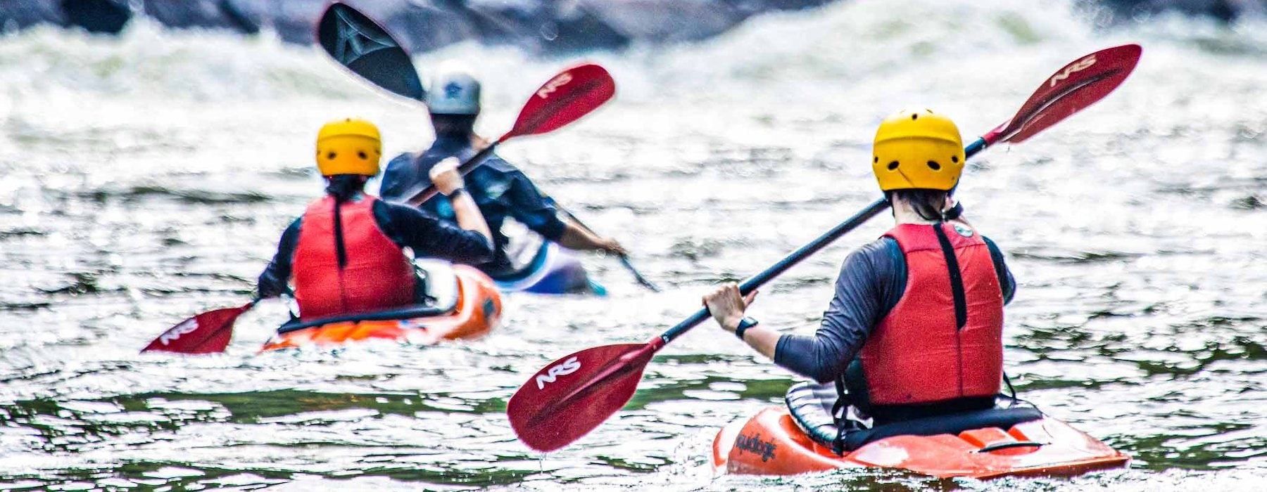 Kayakers with red life vests paddle through rough river Adventures on the Gorge - Lansing West Virginia USA