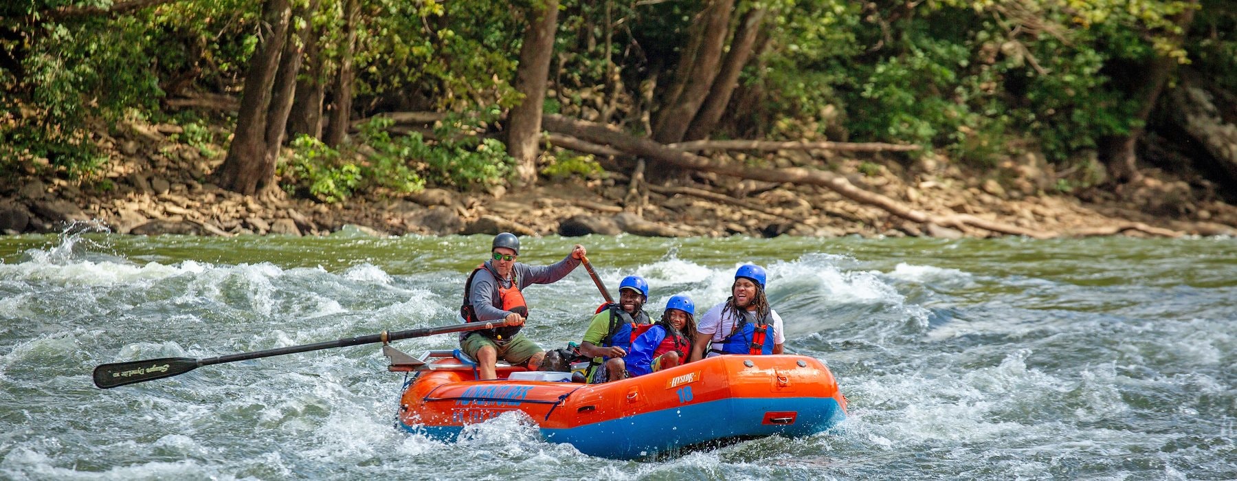 Life jackets are white-water rafting in a bright orange and blue raft Adventures on the Gorge - Lansing West Virginia USA