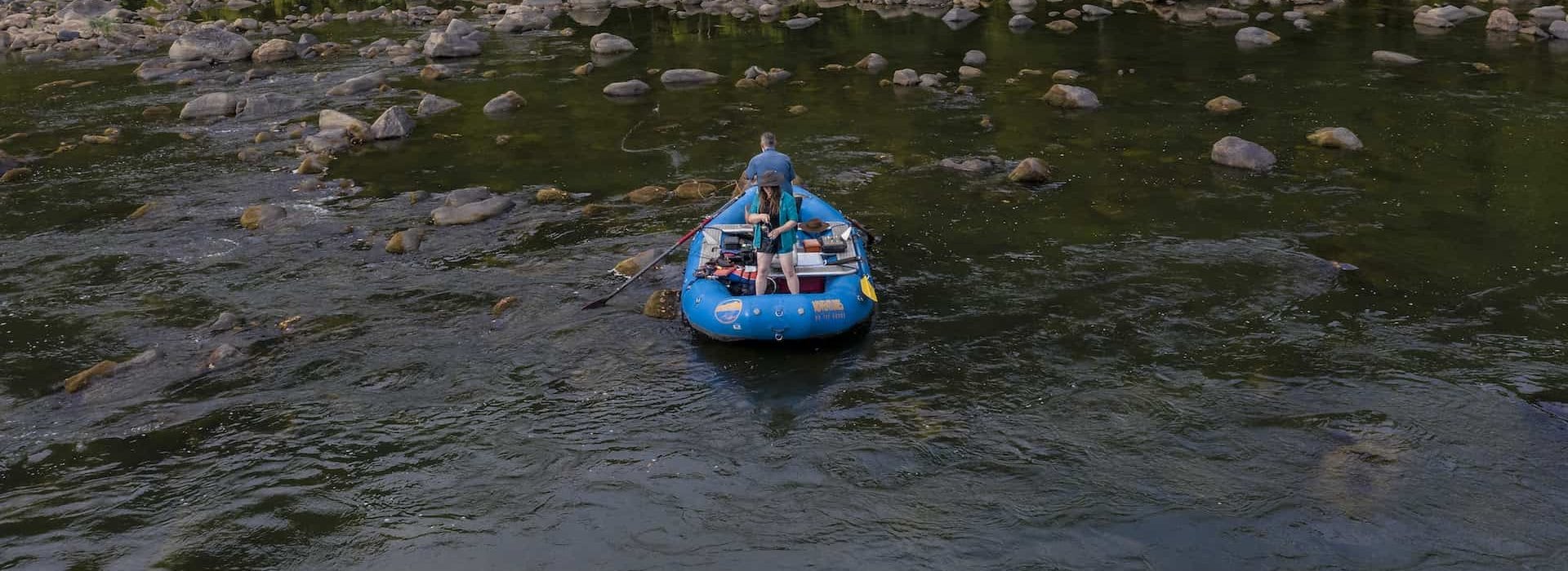 Navigates a blue inflatable raft a rocky river Adventures on the Gorge - Lansing West Virginia USA