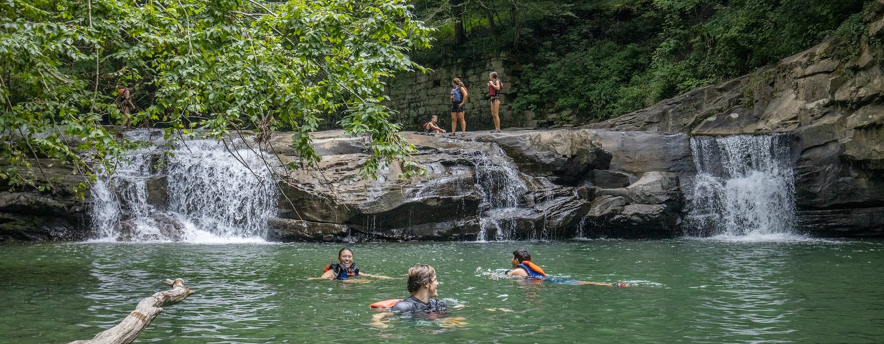 Scenic waterfall flows into a lush green pool surrounded Adventures on the Gorge - Lansing West Virginia USA