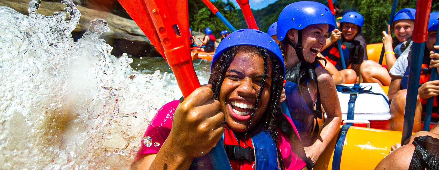 A group of people joyfully paddling together in a raft on a river Adventures on the Gorge - Lansing West Virginia USA