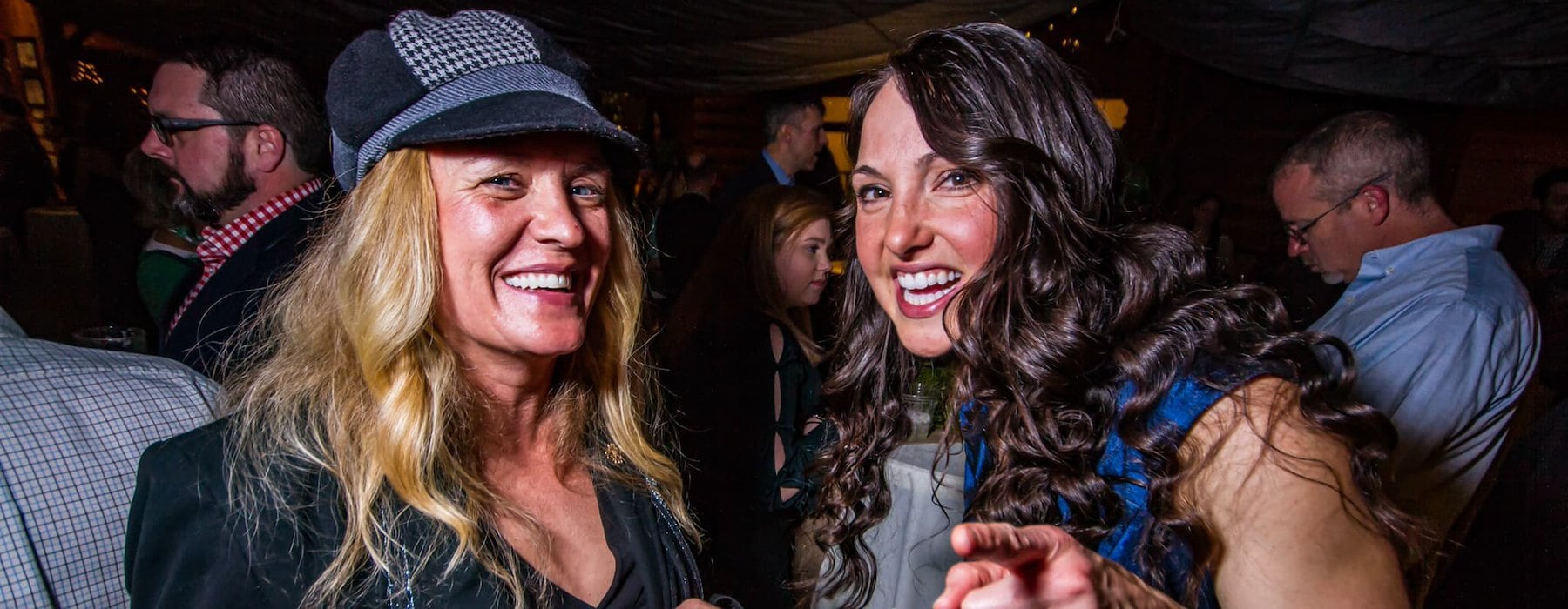 Two women smiling and engaging at a lively indoor party Adventures on the Gorge - Lansing West Virginia USA