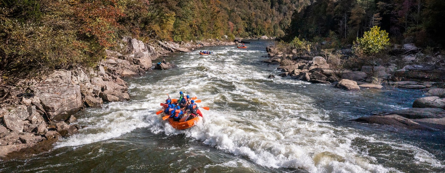 A group of people rafting on a river surrounded Adventures on the Gorge - Lansing West Virginia USA