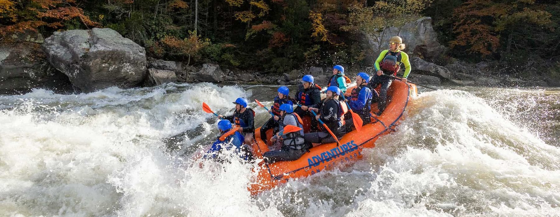 Several individuals in bright rafts maneuvering Adventures on the Gorge - Lansing West Virginia USA