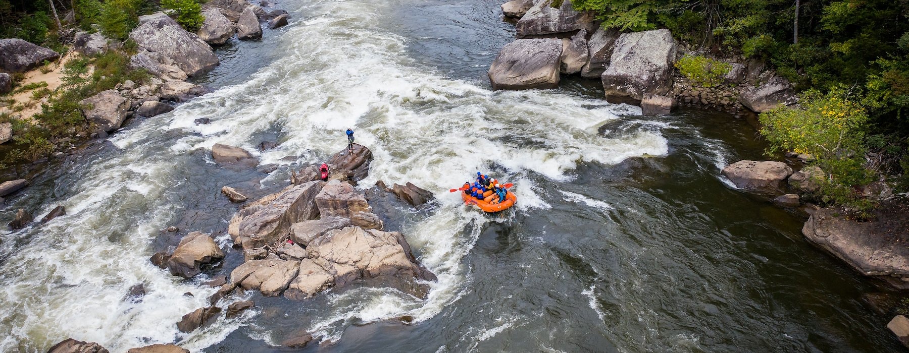 Several individuals in bright rafts paddling together on a river Adventures on the Gorge - Lansing West Virginia USA