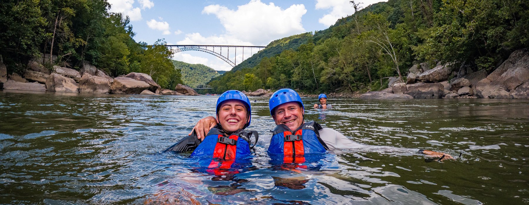 Two individuals wearing life jackets float on a river Adventures on the Gorge - Lansing West Virginia USA