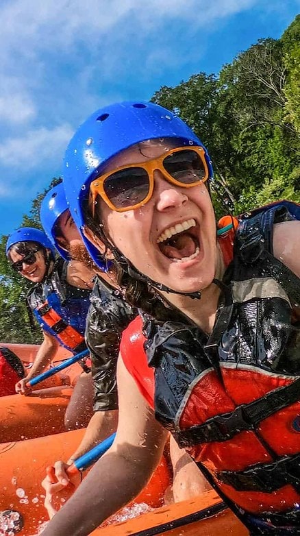 Woman wearing a life jacket and goggles is seated in a raft Adventures on the Gorge - Lansing West Virginia USA