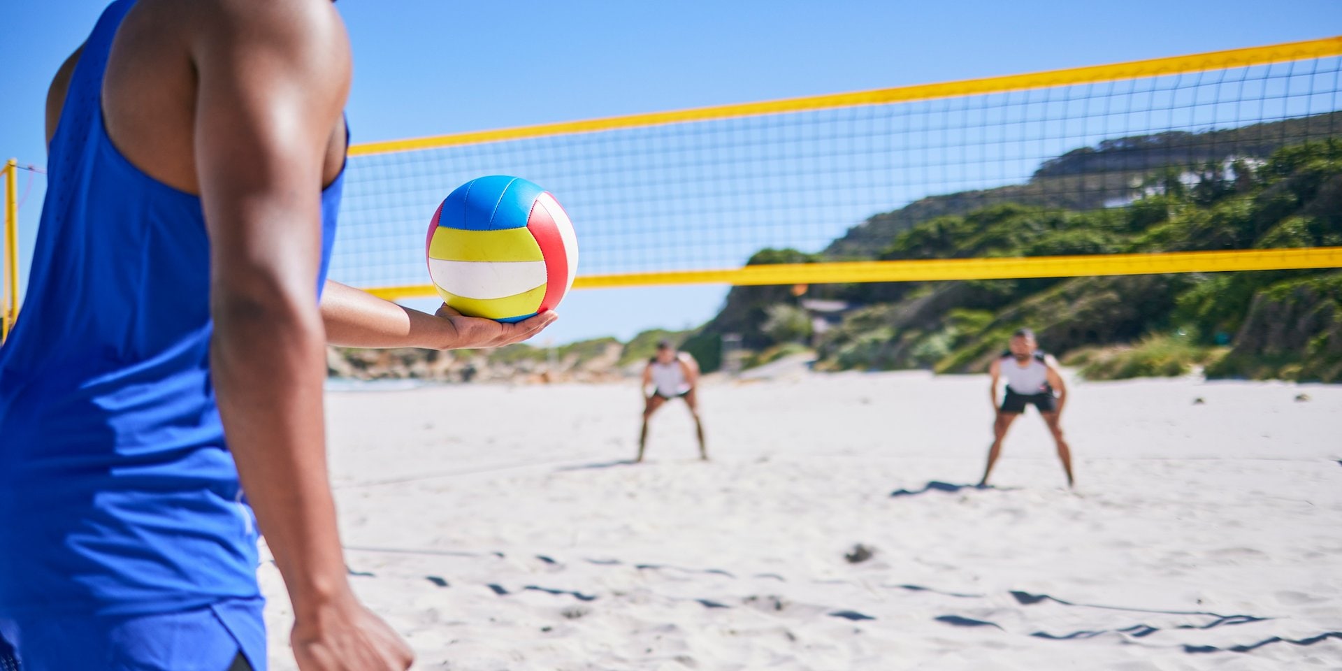 Asilomar Hotel and Conference Grounds Pacific Grove California - A person in a blue tank top holds a colorful volleyball