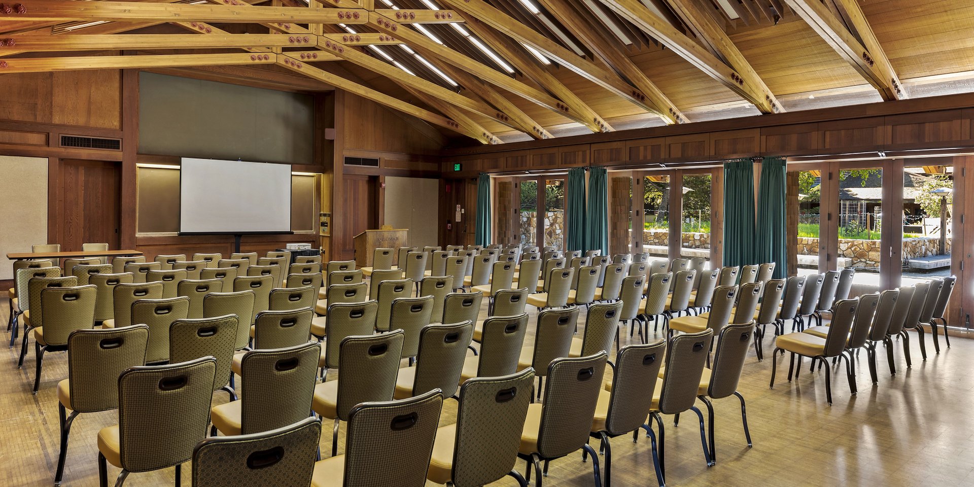 Conference room with rows of empty chairs facing a projector screen Asilomar Hotel and Conference Grounds - Pacific Grove California