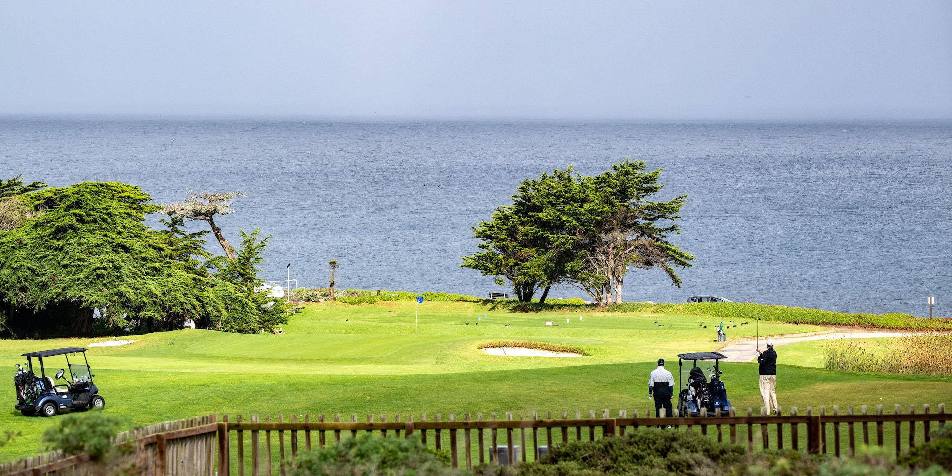 Golf course by the ocean with two golfers and carts Asilomar Hotel and Conference Grounds - Pacific Grove California