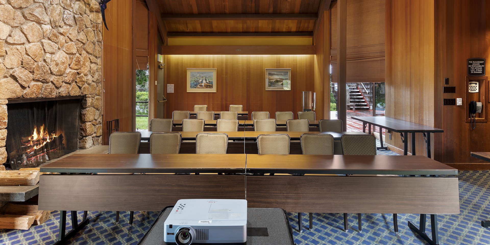 Meeting room with stone fireplace displaying a mounted Asilomar Hotel and Conference Grounds - Pacific Grove California