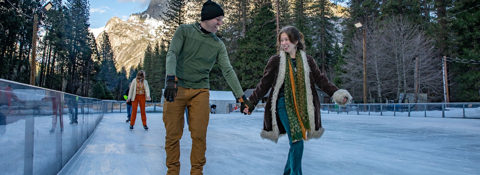 Yosemite National Park Lodging and Activities California United States - Two children and an adult are ice skating on a textured snowy rink