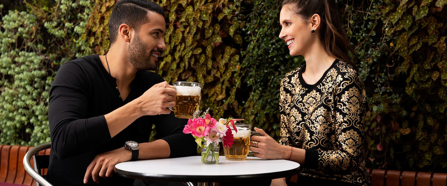 hombre y mujer bebebiendo en area externa parque 93