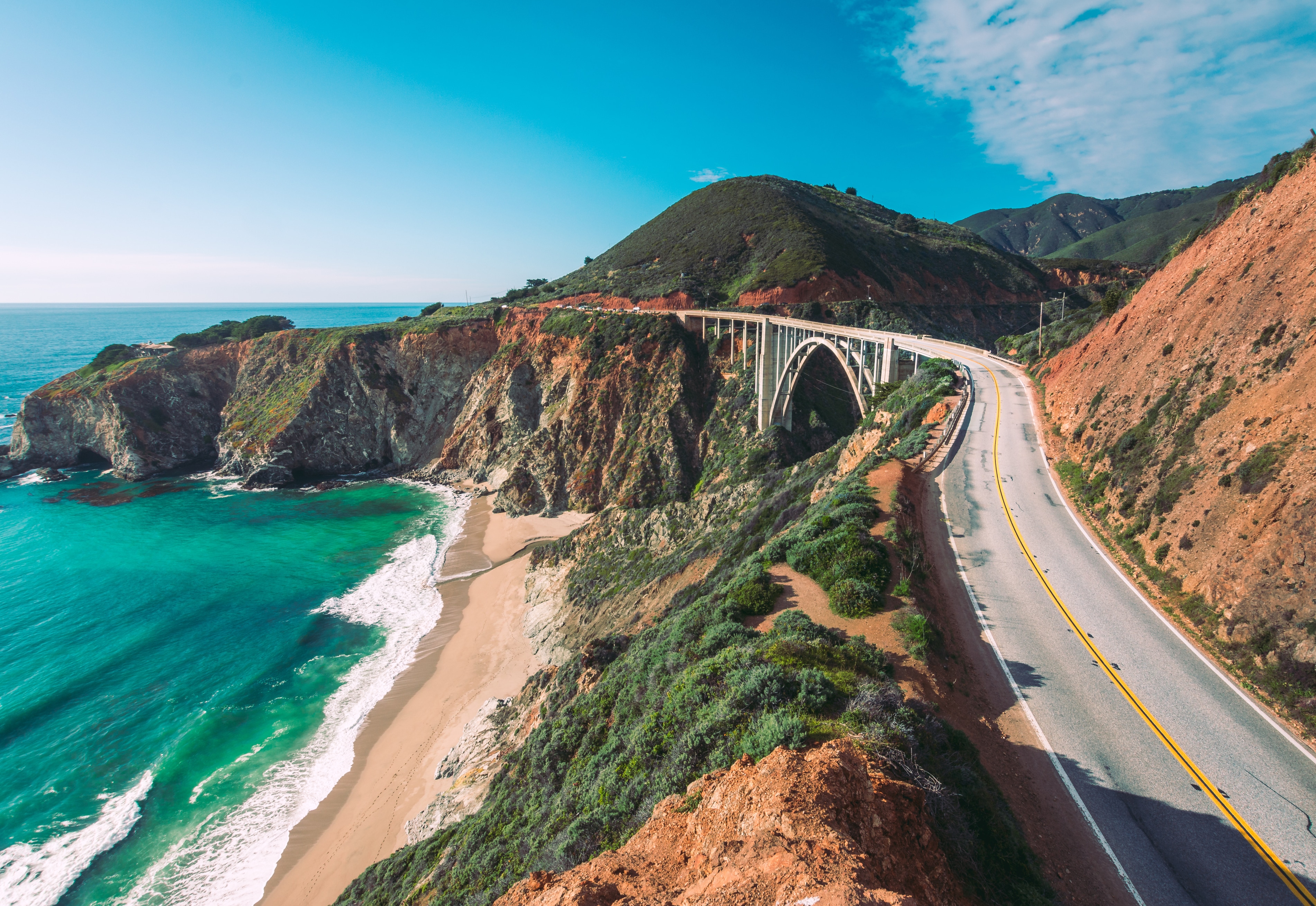 a scenic coastal road with a bridge over a cliff