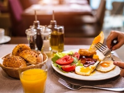 a breakfast plate with eggs, tomatoes, and toast on a table