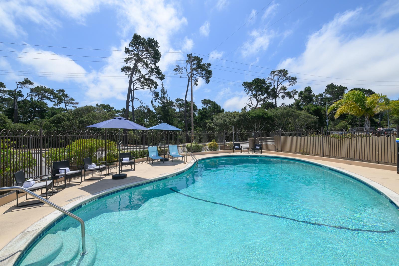 a swimming pool with lounge chairs and umbrellas