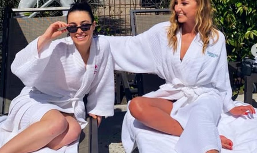 Two women wearing white robes