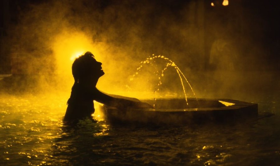 A person in a hot tub with water spouting out of it