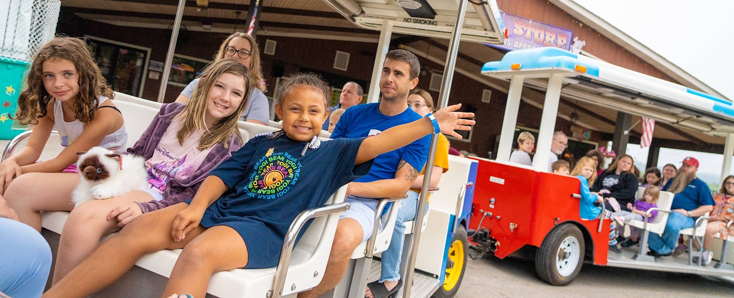 Jellystone Park™ St. Louis West A group of people sitting on a small vehicle