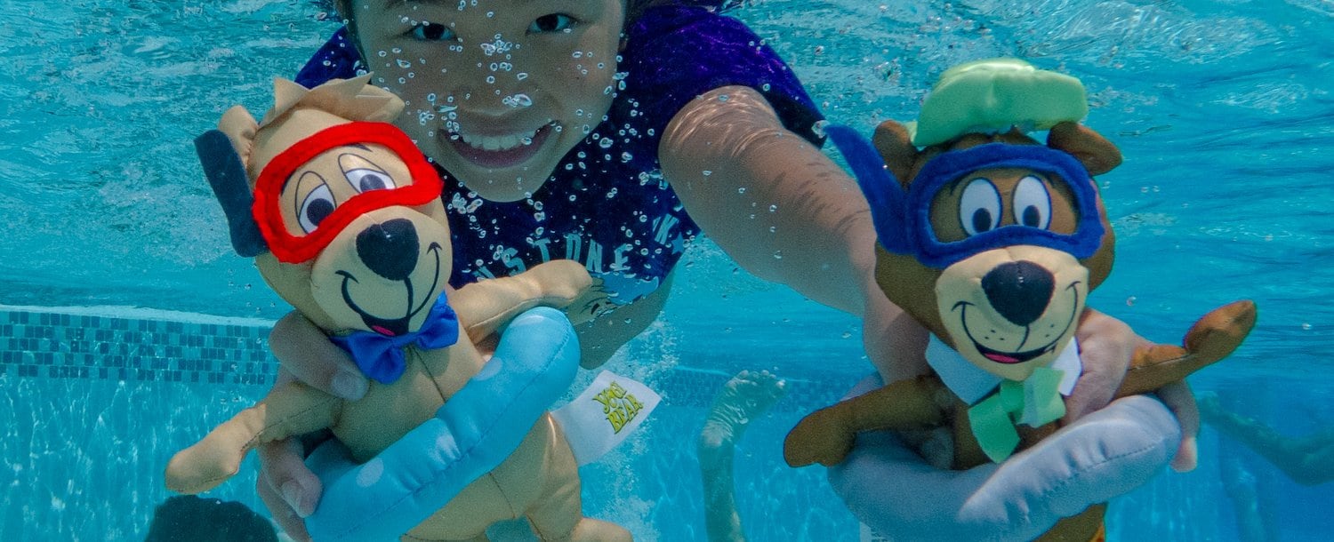 A group of people swimming in a pool with stuffed animals