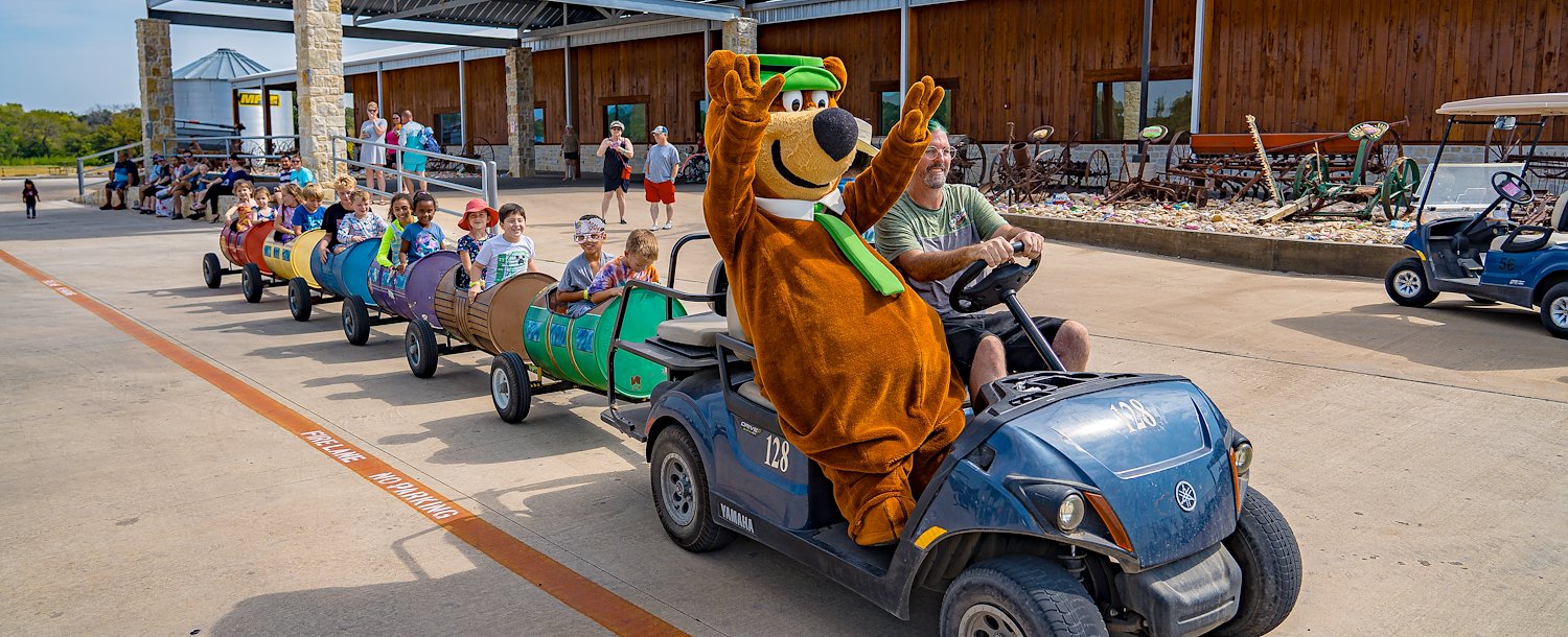 Yogi Bear™ in the lead on the barrel train at Jellystone Park™ North Texas