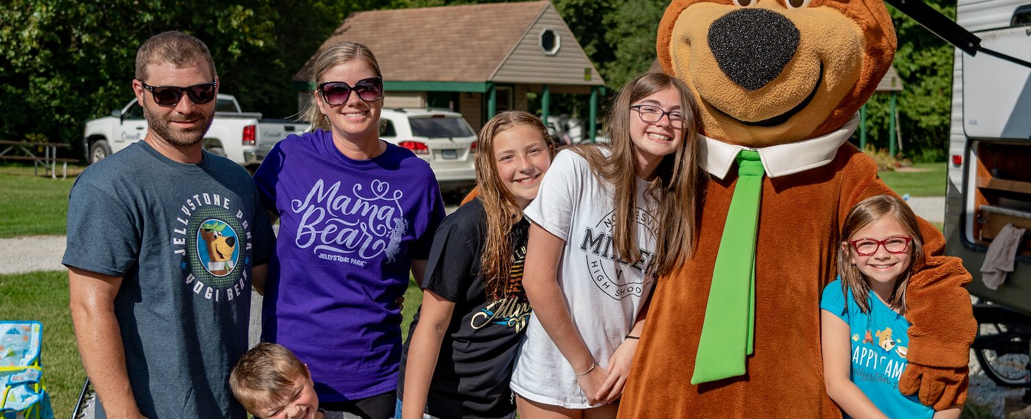 A group of people posing with a Yogi Bear in Jellystone Park™ Williamsburg