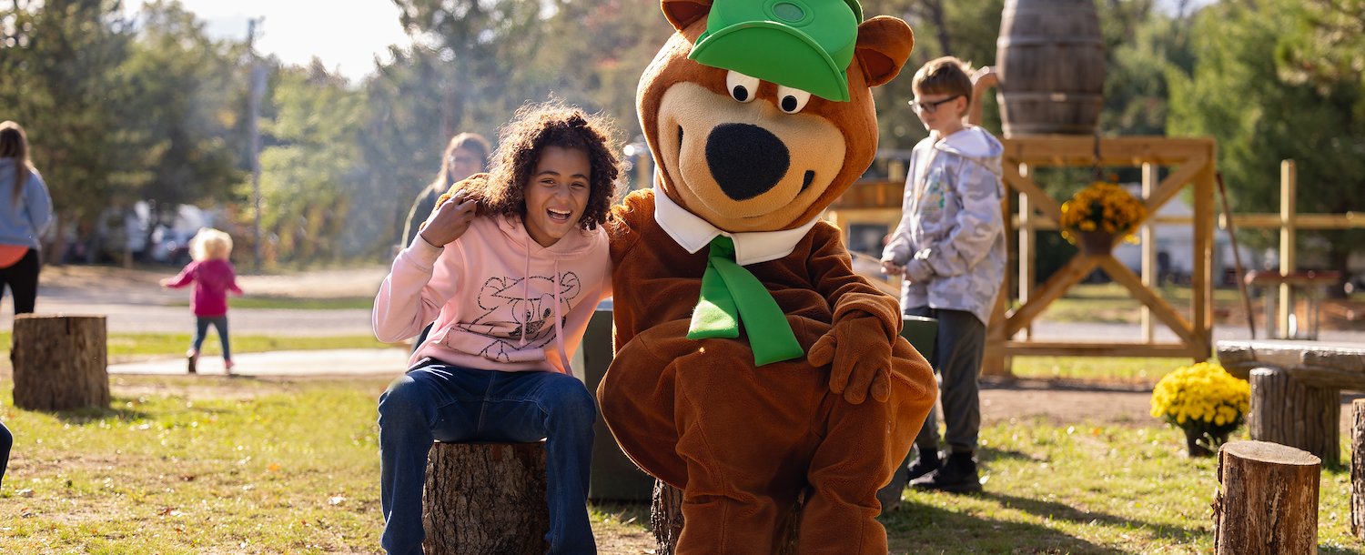 Happy girl with Yogi Bear in Jellystone Park™ Williamsburg