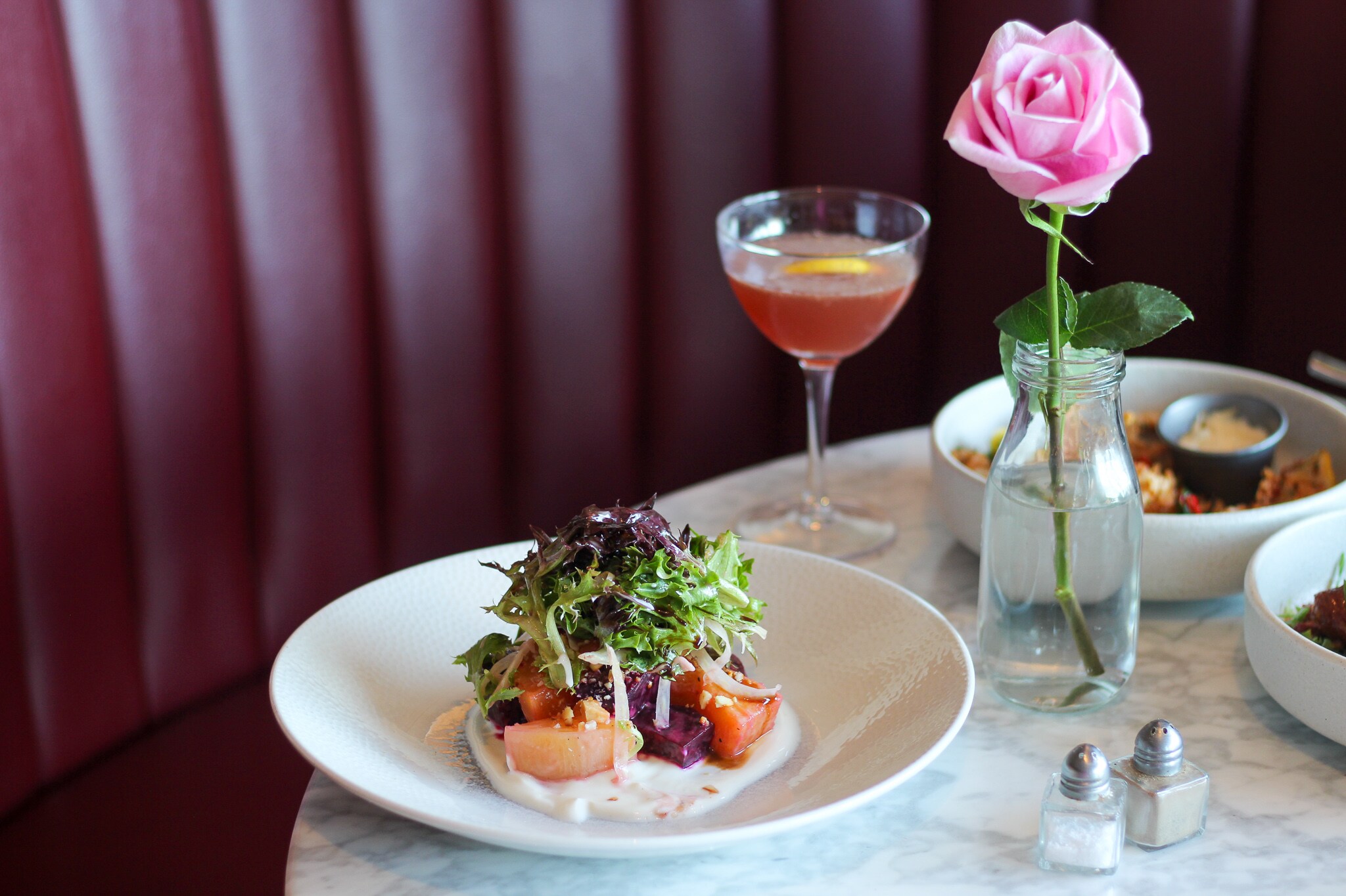 Fresh salad served with a drink at ROSE Town Kitchen & Bar, Boston Downtown