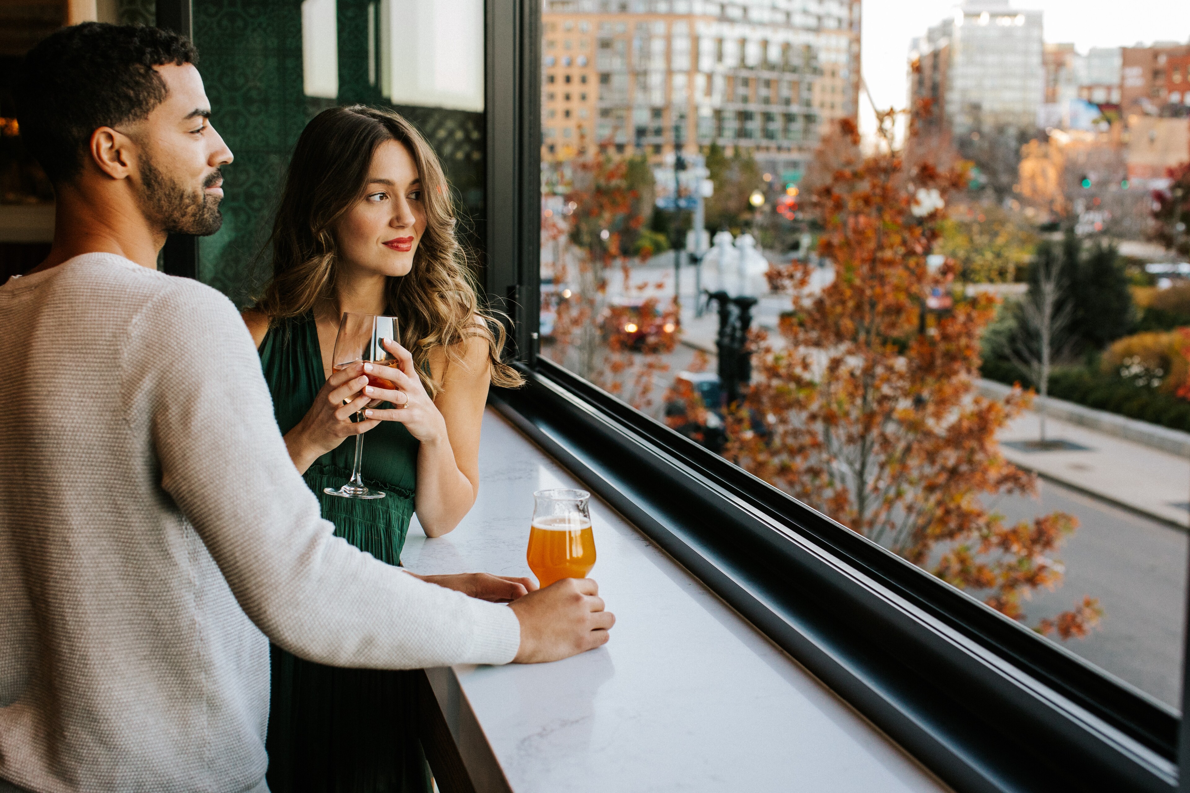 A couple enjoys drinks with a city view at Canopy by Hilton Boston Downtown