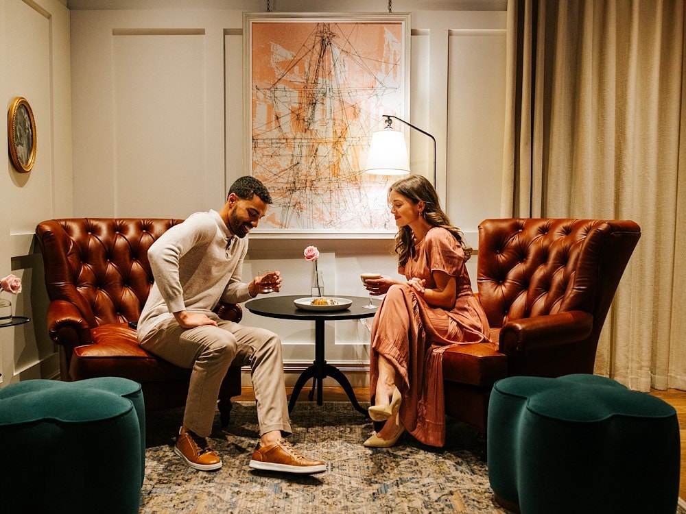 A couple enjoys drinks at Canopy by Hilton Boston Downtown in a cozy setting.