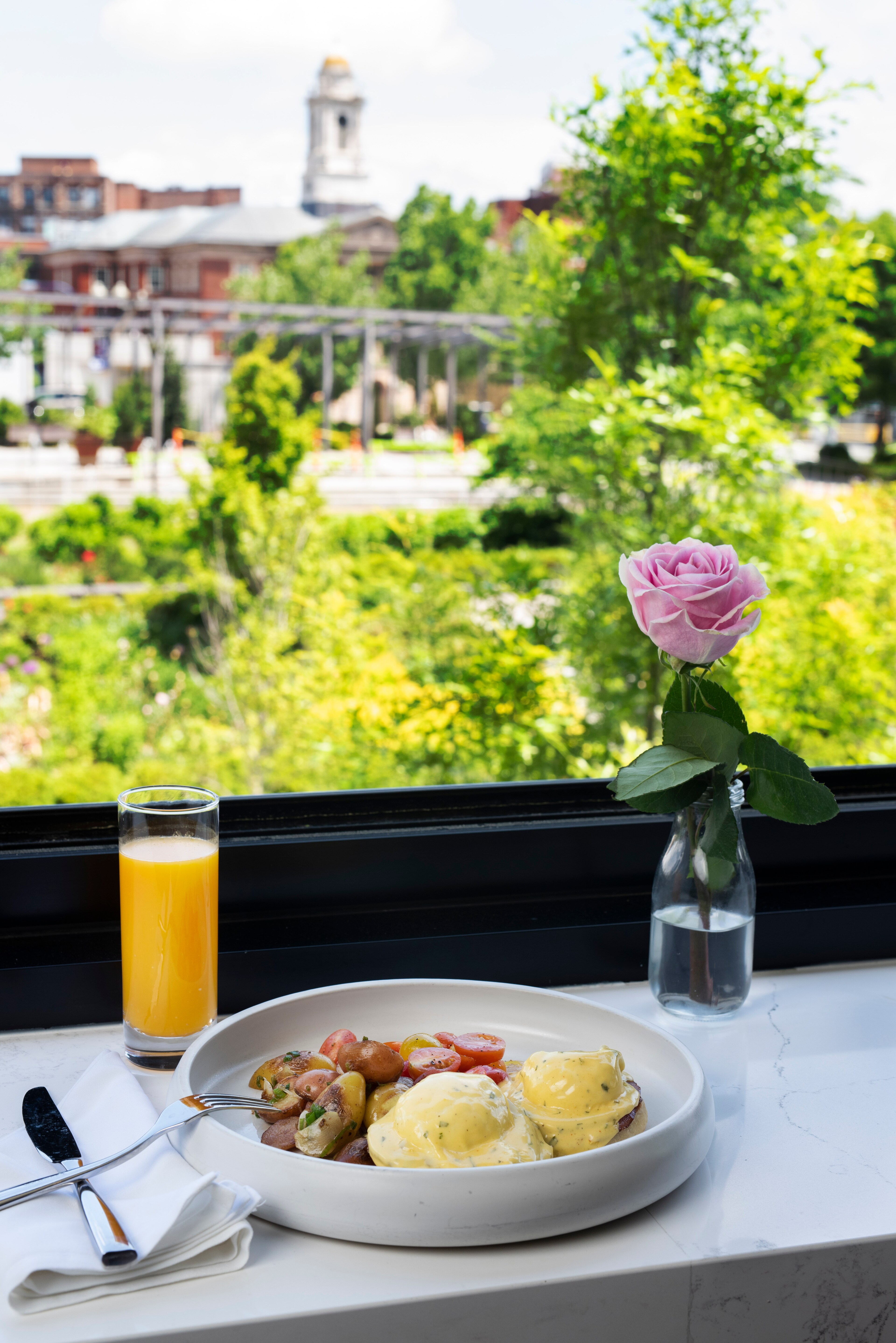 Breakfast plate with an omelet, fresh fruits, juice, coffee, and toast on a dining table