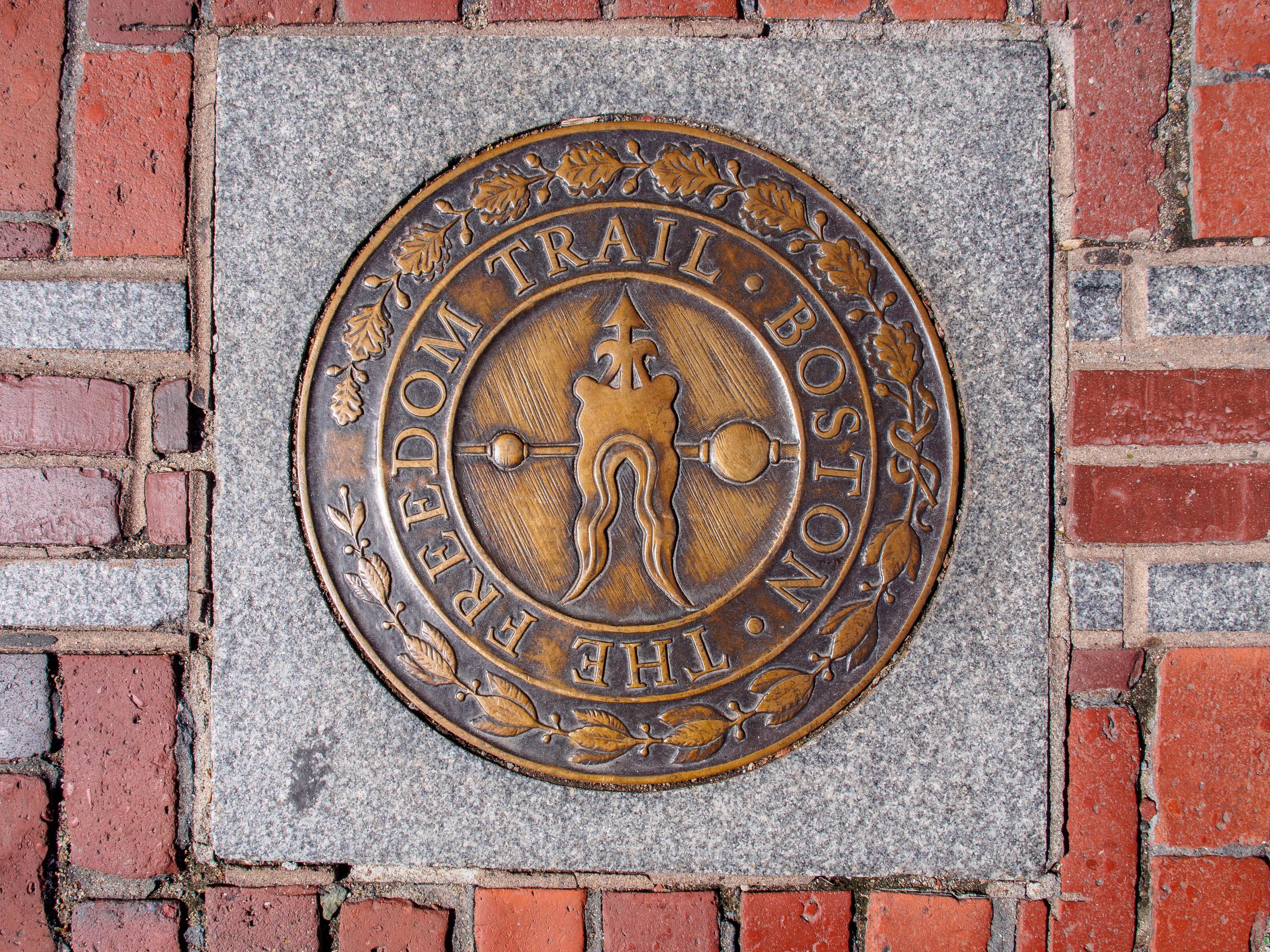 The Freedom Trail marker embedded in a brick walkway along the historic Freedom Trail in Boston, MA.