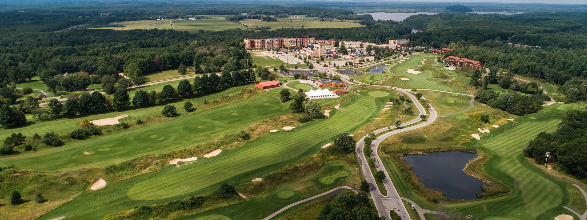 Aerial view of a lush golf course with fairways, sand traps, and a pond - Chula Vista Resort, Wisconsin Dells, Wisconsin