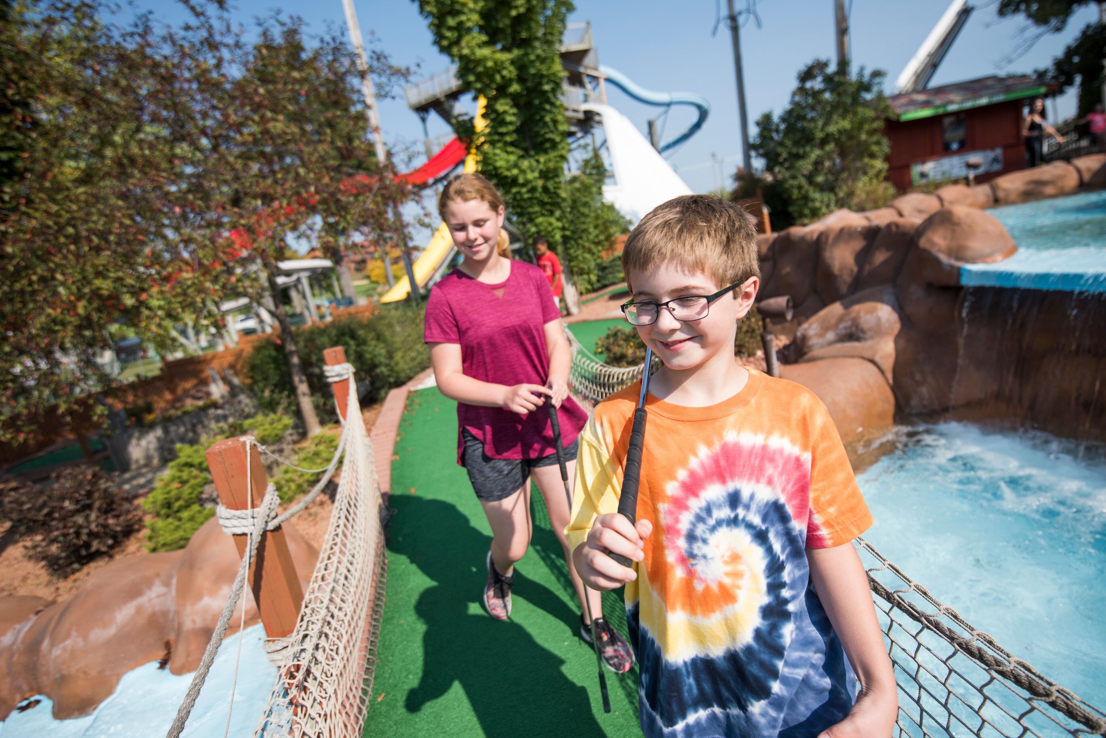 A boy and girl walking on a miniature golf course