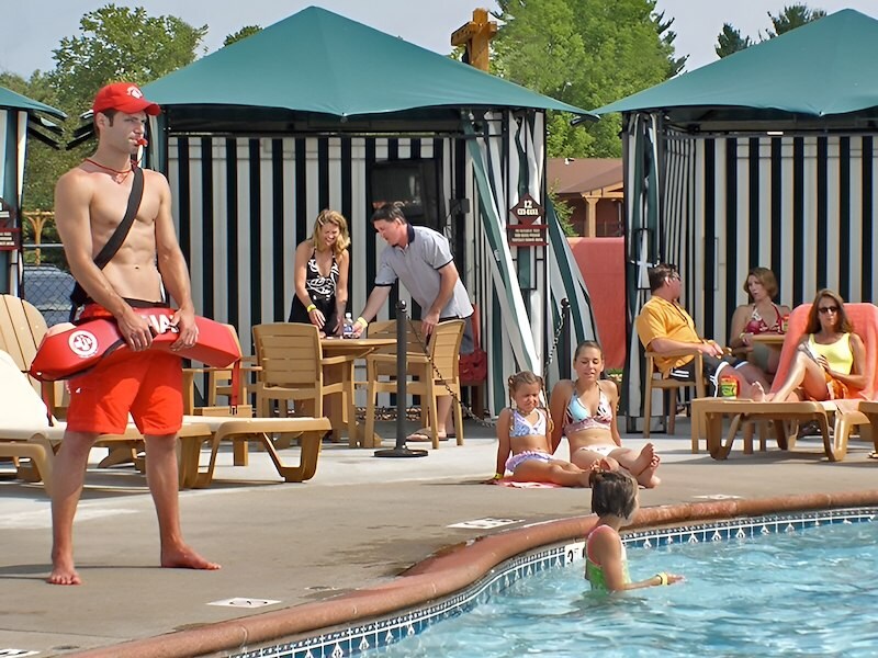 A man holding a surfboard next to a pool