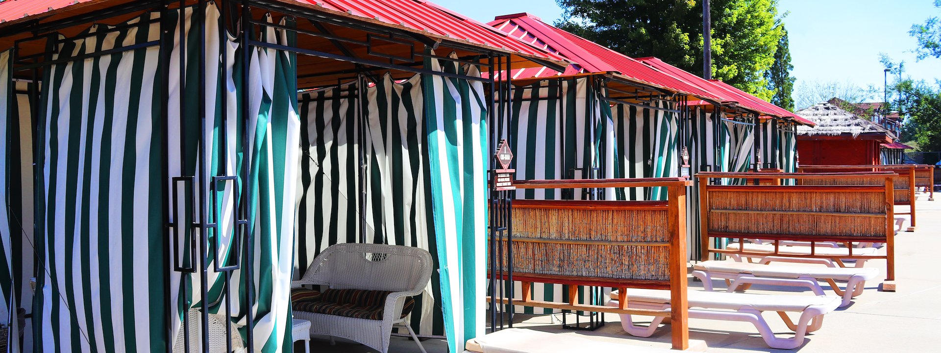 Row of poolside cabanas with red roofs and green-striped curtains, Chula Vista Resort, Wisconsin Dells, Wisconsin