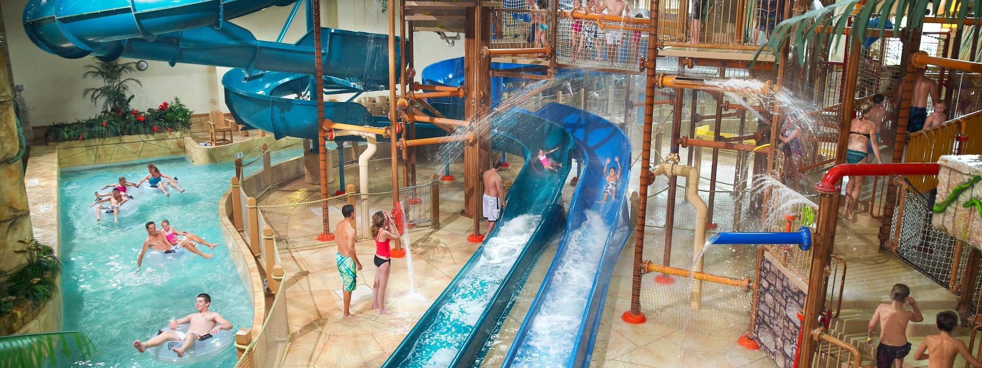 Indoor water park with excited people and children enjoying winding blue slides, Chula Vista Resort, Wisconsin Dells