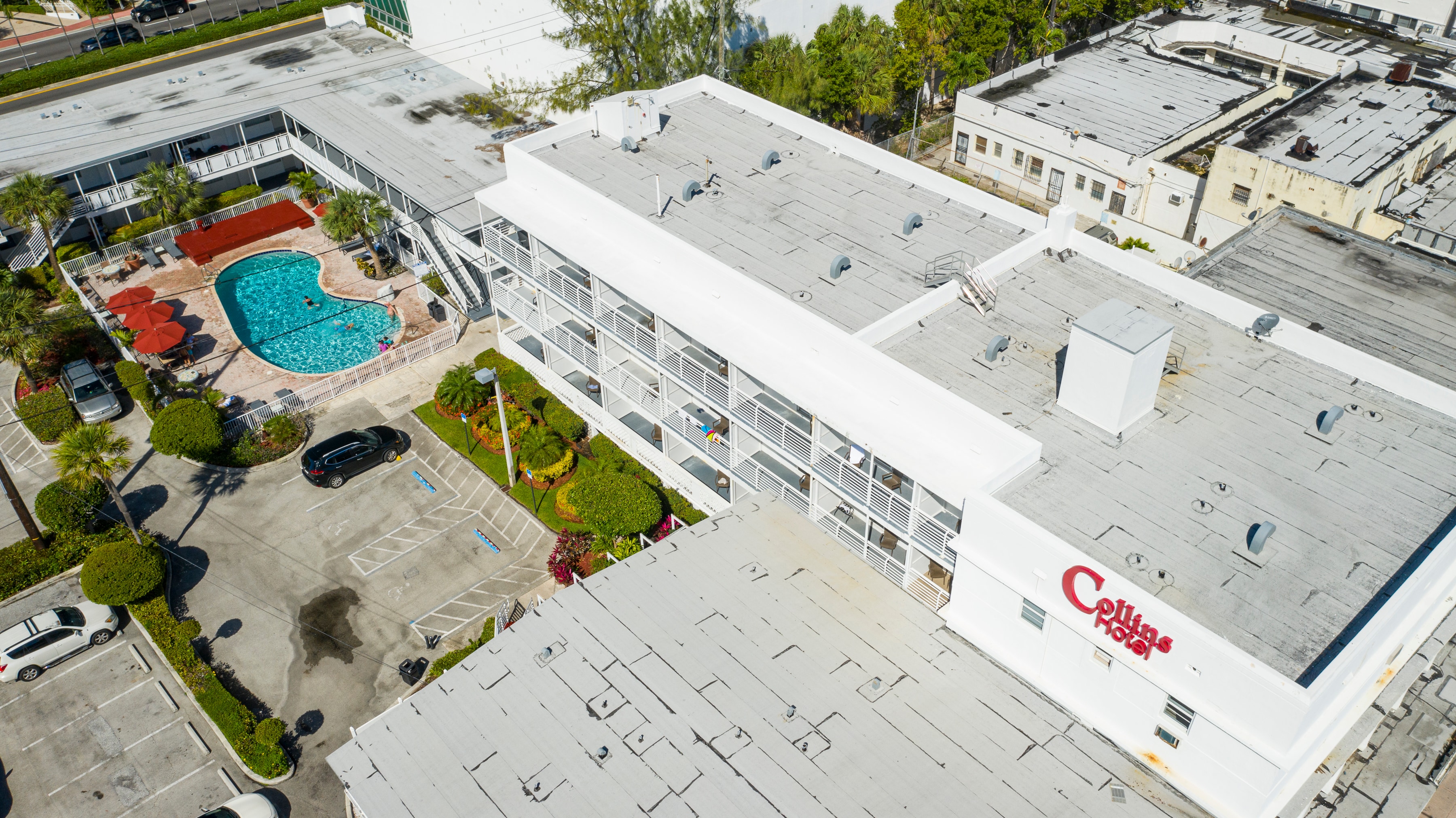Aerial view of the Collins Hotel with its pool, parking lot, and building