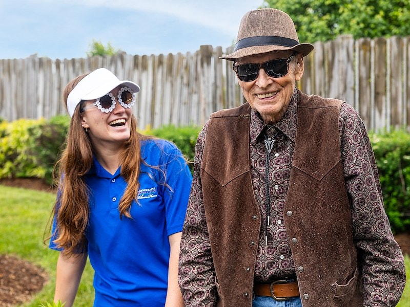 An associate smiling at a resident while gardening together
